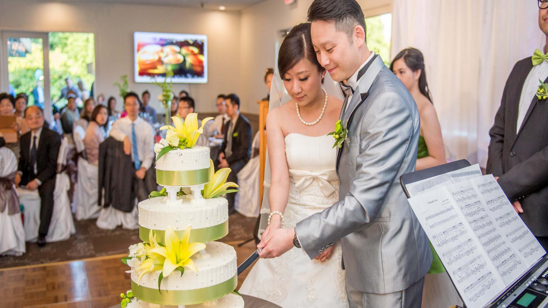 Couple cuts their wedding cake at the Burnaby Mountain Clubhouse