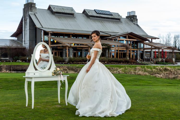Bride posing for wedding photos with the luxurious Riverway clubhouse in the background