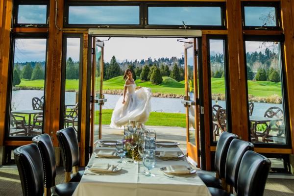 A bride stands in the doorway of the Riverway clubhouse overlooking the golf course